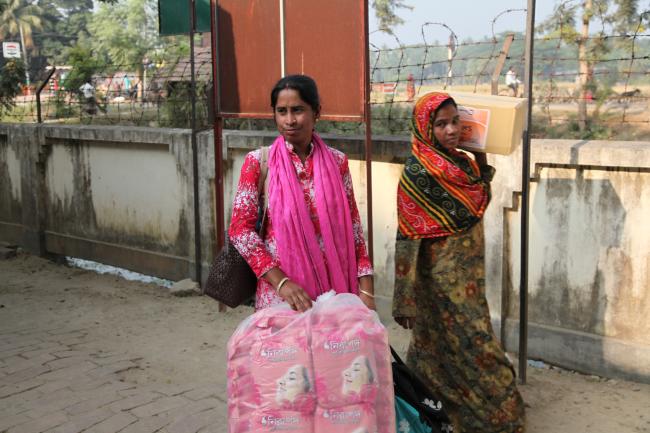 BRAC staff member (left) from Jessore district with sanitary napkins for schools