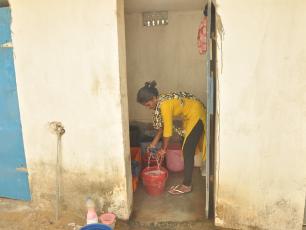 Woman cleaning toilet - Odisha, India