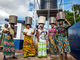 African women with water buckets on their heads. Photo: Simavi