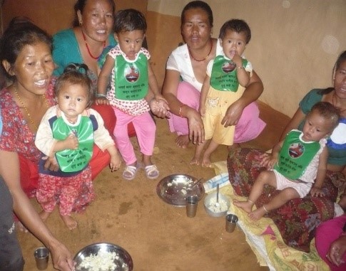 Mother with babies wearing bibs with hygiene messages